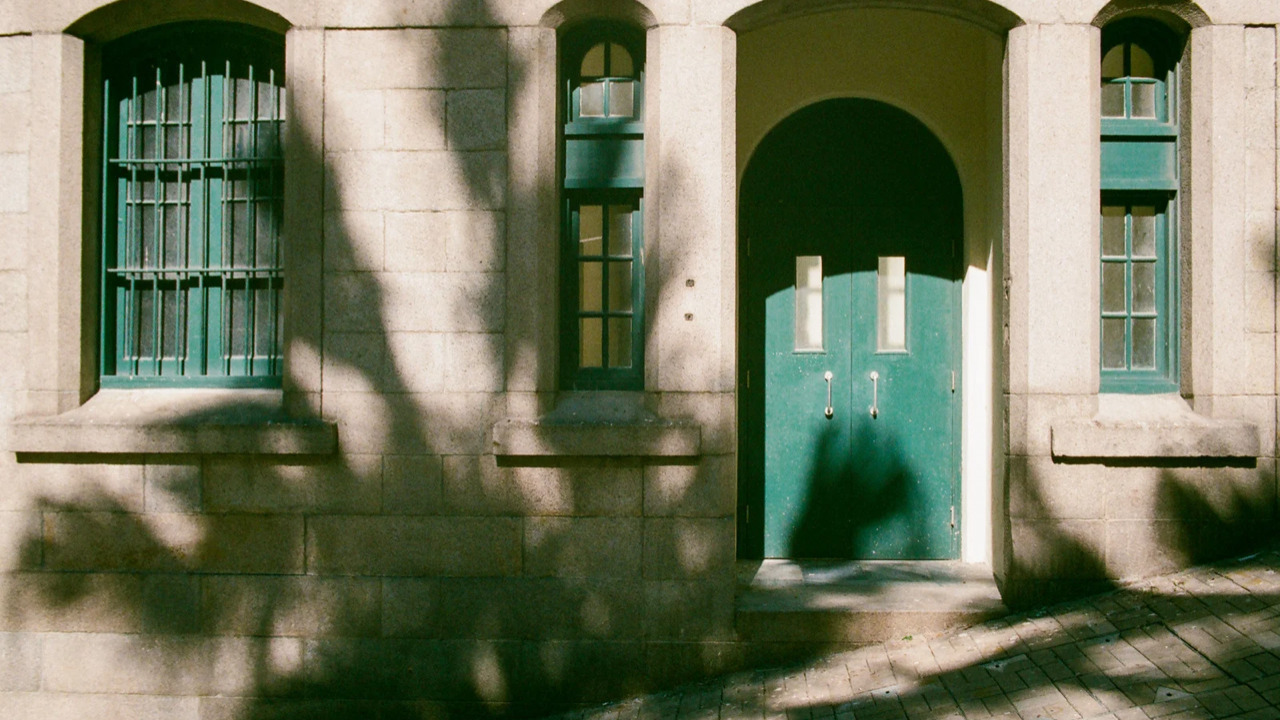 深い緑色の窓枠と玄関の洋風の家